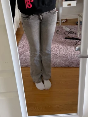 Ljusgrå bootcut jeans - Säljer ett par ljusgrå bootcut jeans. Baktill finns två fickor med ett svart zigzag-mönster. Jeansen har normalhög midja kanske lite mer lågmidjade❤️Knappt använda!