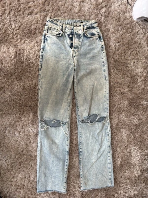 Ljusblå raka jeans med hål - Säljer ett par ljusblå raka jeans med hål över båda knäna. Jeansen har hög midja, har en avslappnad passform. Perfekta för en trendig och avslappnad stil.✨
