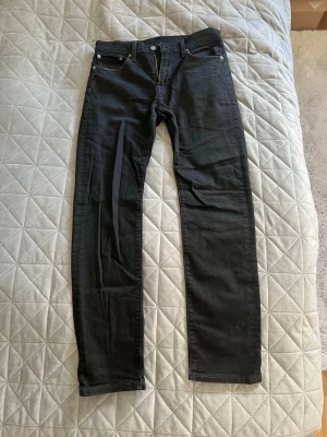 Svarta slim fit jeans - Säljer ett par svarta slim fit jeans med klassisk femficksdesign och silverfärgade nitar. Jeansen har normal midja och raka ben. Jeansen har lite stretch för extra komfort. Perfekta till en avslappnad look. W29/L32
