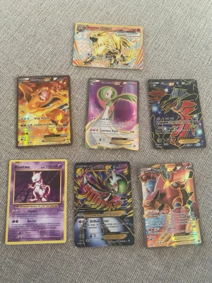 Pokémonkort EX, GX & BREAK samling - Säljer en samling med sju Pokémonkort, bland annat Charizard EX, Mewtwo, Arcanine BREAK och flera GX/EX-kort. Korten har färgstarka illustrationer och holografiska effekter. Perfekt för dig som vill utöka din samling med unika och coola kort från Pokémon TCG. Två av korten är fejk som finns bild på resten ör äkta och allt säljes tillsammans och fint skick kan säljas enstaka för rätt pris 