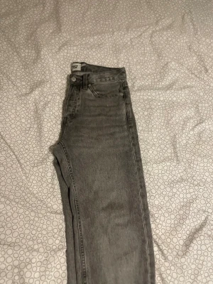 Gråa raka jeans - Snygga grå jeans med rak passform och klassisk femficksdesign. Jeansen har normal midja och är tillverkade i ett mjukt denimtyg. Perfekta för en avslappnad och trendig look.