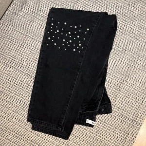 NAKD jeans - Svarta jeans från NAKD med pärlor på knäna, sitter som S/M