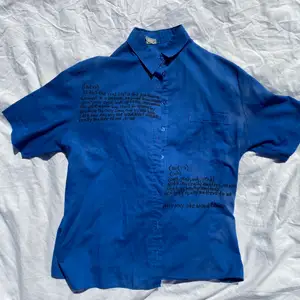 Blå skjorta med bohemian rhapsody-queen lyrics på 