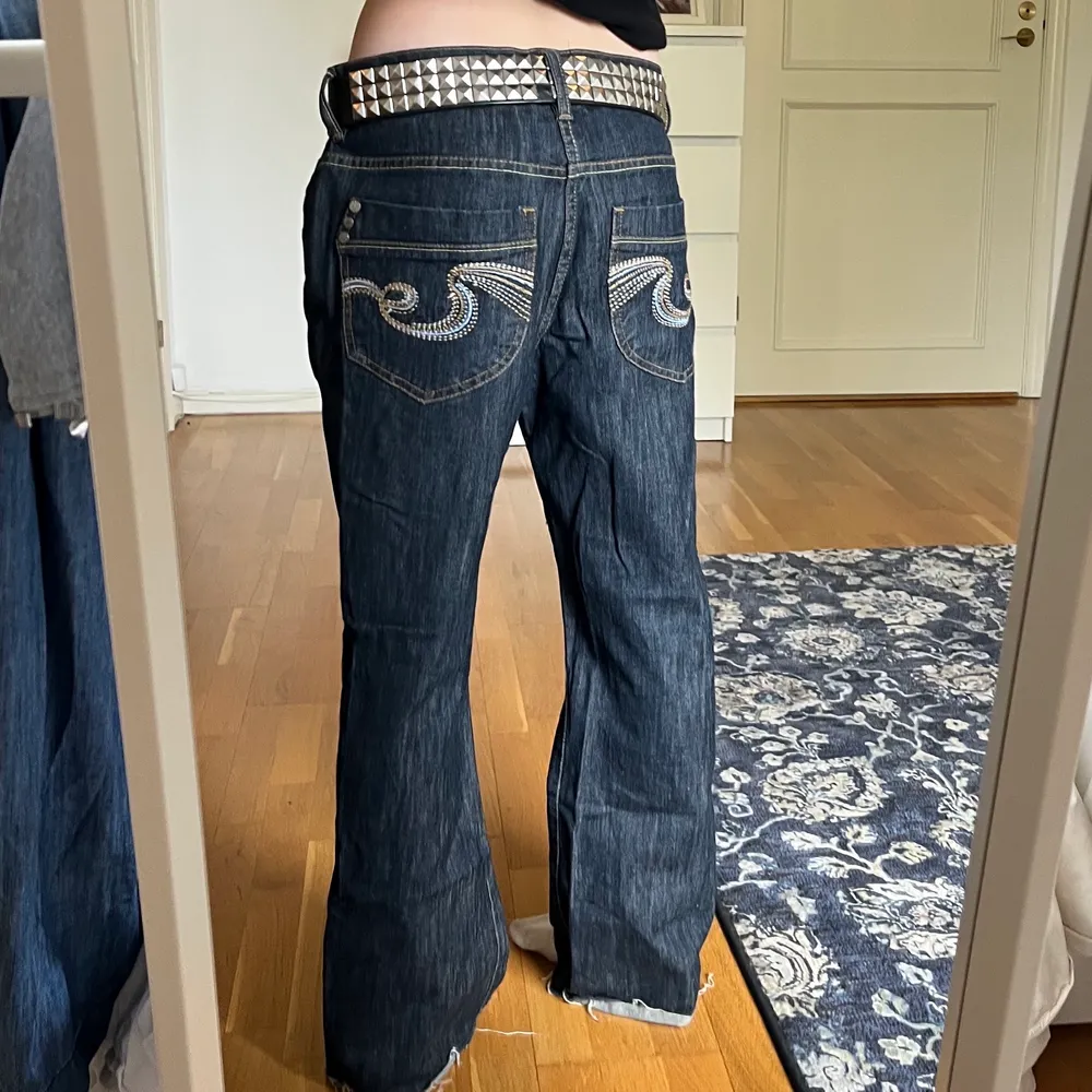 Jag säljer ett par mörkblåa låg midjade jeans med riktigt coolt tryck på bakfickorna. Jag kan mötas upp och frakta, köparen står då för frakten💕  . Jeans & Byxor.