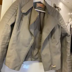 Chiquelles moto jacket i färgen grå. Den har en slutning på ryggen (se bild 2) men den syns inte om jackan är vanligt (bild 3)