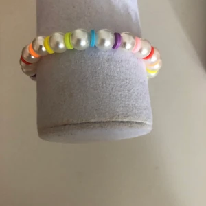 Regnbågigt armband  - Regnbågigt armband med vita pärlor.   15kr plus 12kr frakt  Mär din vrist för att veta din storlek  Instagram: smileyyjewelry