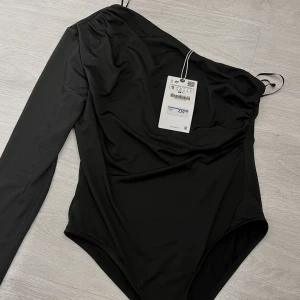 Body från Zara - Säljer denna festbodyn från Zara helt oanvänd med prislappen kvar!