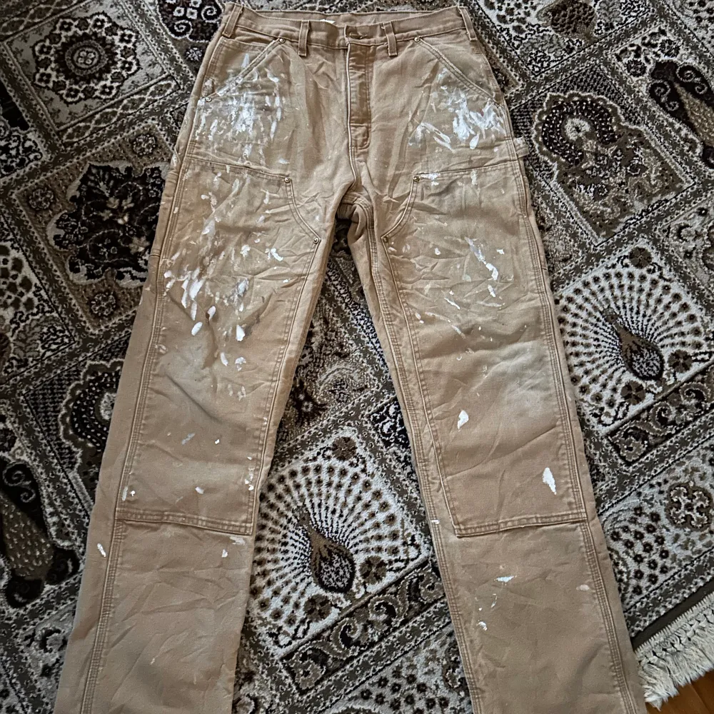 riktigt snygga carhartt carpenter byxor i en beige färg. sitter väligt bra och ör raka. byxorna har ganska mycket färg fläckar på sig som enligt mig är snyggt samt lite slitna här och där. söker byten eller bud på dessa. Jeans & Byxor.