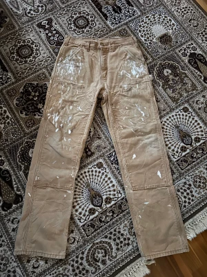 carhartt carpenter - riktigt snygga carhartt carpenter byxor i en beige färg. sitter väligt bra och ör raka. byxorna har ganska mycket färg fläckar på sig som enligt mig är snyggt samt lite slitna här och där. söker byten eller bud på dessa