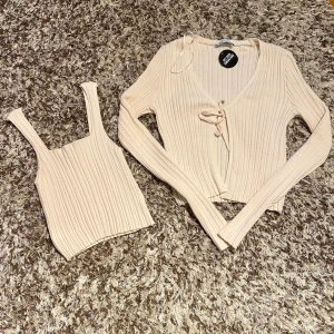 Beiget set  - Beiget jättegulligt set. Helt nytt aldrig använd, lapparna kvar. Strl XXS, Säljer pga för liten. Setet består av ett linne och kofta, koftan går även att använda som en vanlig tröja. Köpare står för frakten💕