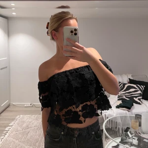 Rut & circle - En axellös topp i färgen svart med blomster mönster, i storlek s.