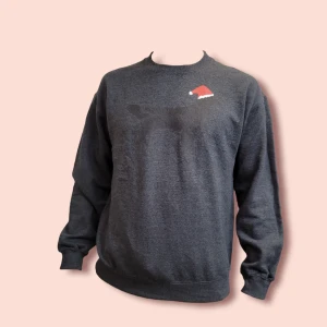 Hund jultröja - Framsida: hund tryck. Baksida: Plain. Detaljer: vanligt tryck. Smått söndrig i trycket.  ↔️ Bredd: 54cm.   ↕️ Längd: 57 cm.   ↘️ Ärm: 55 cm.   🔄Storlek: M.   🔃Passform: Loose fit.   ⚪ Färg: Mörkgrå.