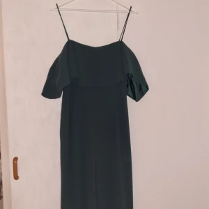 H&M jumpsuit - Mörkgrön jumpsuit med off the shoulder ärm. Vida i benen och korsettlining i överdelen. Prislapp sitter kvar, aldrig använd.
