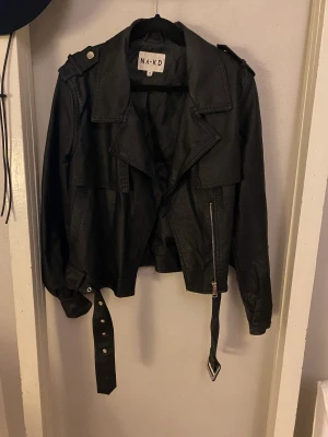 Skinnjacka NA-KD - Skinnjacka i Faux leather från NA-KD. Fina detaljer som fickor och fickor. Säljs då den inte används 🌺 jag är en storlek S/M och den sitter perfekt på mig, jag kan ha en tjocktröja under. 