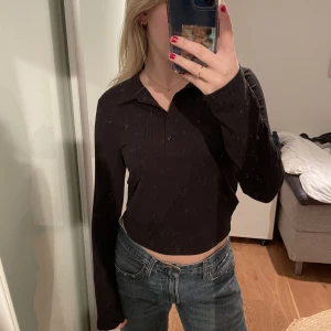 Ribbad svart långärmad tröja med krage från Gina Tricot  - Ribbad svart longärmad tröja med krage från Gina Tricot. Liten i storleken. Storlek L, men jag har vanligtvis S/M. Lite kortare i modellen. Aldrig använd. Väldigt bra skick. Pris kan diskuteras. Skriv om ni vill köpa!