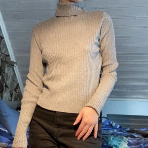 Grå ribbad tröja med polokrage - En ganska tunn grå ribbad turtleneck/polokrage från monki. Perfekt till att lagra med eller ha den bara som den är. 60kr frakt om du köper genom mig och inte köp nu :)