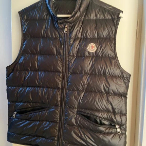 Moncler gui väst svart - Storlek: 3    I mycket bra skick, , kvitto finns. Köpare står för frakt,  mer bilder kan skickas vid intresse