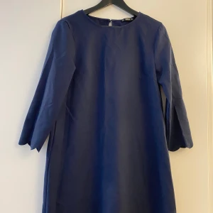 Märkblå klänning Shein M - Mörkblå klänning med mönster i ärmslut och kjolkanten. Storlek M.