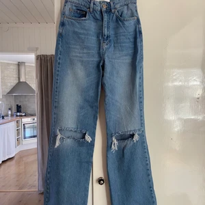Blåa jeans strl 34 - Jättesnygga jeans från stradivarius, de har slitningar i knäna! Har tyvärr aldrig använt dom då de legat i min låda!