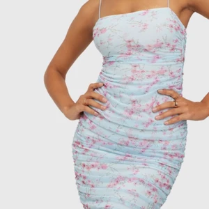 Blå klänning - Blå blommig klänning med drapering