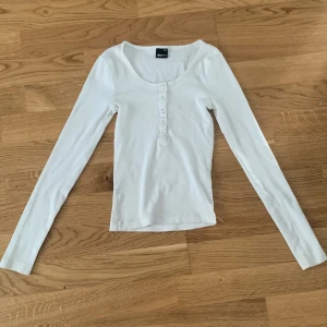 Gina  - En vit basic tröja och är i storlek xss den är ganska lite i storleken men den är stretchig inga fleckar eller skador