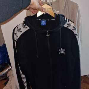 Vintage Adidas hoodie  - Vintage Adidas huvtröja i mycket gott skick. Tre Foil märken på ärmar, bröst och luva. Står 2xl på lapp men är mer som L/XL