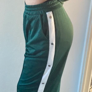 Gröna baggy byxor, stl M - Använda några gången men är för stora för mig, stl M men känns som L. Lite glansigt material och dem har även knappt längs med sidan av benet som man kan knäppa upp om man vill.