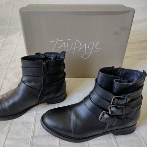 Svarta skinnboots/boots i läder från Taupage, storlek 38 - Skitsnygga svarta läderboots från Taupage. Sparsamt använda och bara lite slitna allra längst bak i klacken (går om man vill att byta ut yttersulan på klacken och då blir de som nya). Skolkartongen som är med på bilden har jag inte kvar. Storlek 38. 