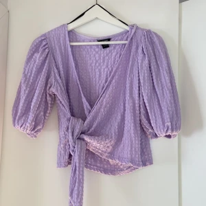 Omlott topp  - Omlott topp med ballongärm från Monki. Aldrig använd. Stl M men kortare i längden och mindre i stl så passar XS-M beroende på hur man vill att den ska sitta. 