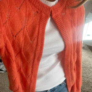 Stickad kofta  - Stickad kofta från saint tropez. Storlek L. Röd/orange färg