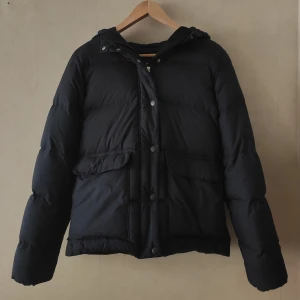 Dunjacka GANT stl XS - Fin stilren dunjacka från GANT storlek XS. Mörkblå. Mycket fint skick, ser dom ny ut. Varm och passar för kalla höst- och vinterdagar. 