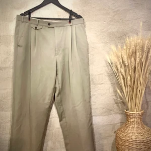 Japansk inspirerade Kostym byxor  - Easyline högmidjade kostymbyxor - fick detalj på framsida av byxan -metallbricka i bältesrem på framsida -breda vid lår Storlek och passform: Midja 96cm Längd 107cm Köpta för deras americano-japanska stil. Med pösig passform lik Yohji Yamamoto skick 7/10