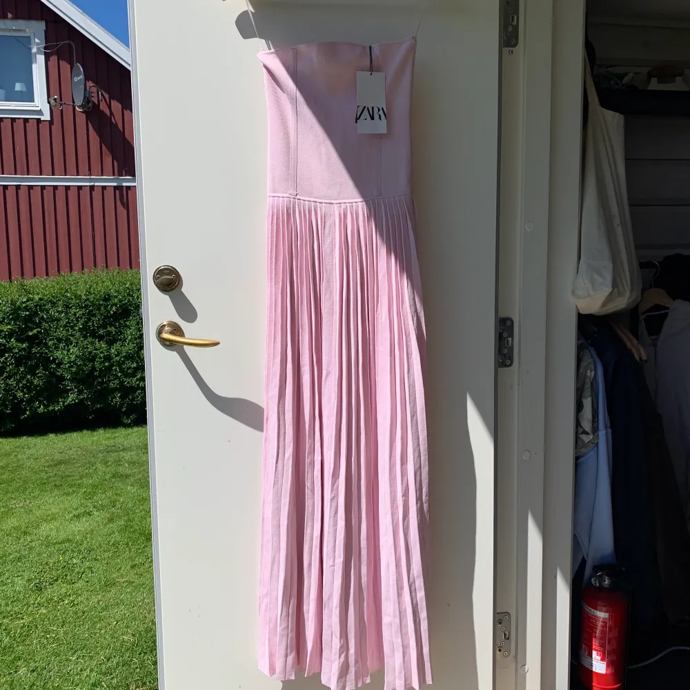 Superfin ljusrosa klänning med korsett i toppen och plisserad kjol. Sitter perfekt och är true to size. Helt nyköpt och aldrig använd. Lapp finns kvar! Köparen står för frakt. . Klänningar.