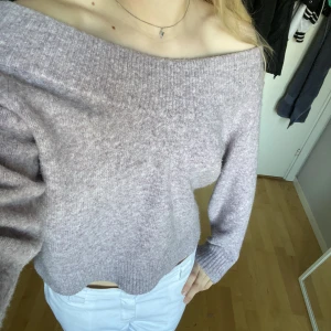 Stickad tröja  - Stickad tröja som man kan ha både v-ringad och off- shoulder. I stlk M men passar S. 