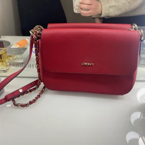 Väska DKNY - Väska från DKNY! Gott men använt skick. DKNY-loggan lite repig (syns på sista bilden). Går att justera banden så att väskan kan bäras crossbody samt över axeln.