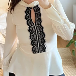 Vit blus med svart spets - Vit blus med svart spetsdetalj framtill. 