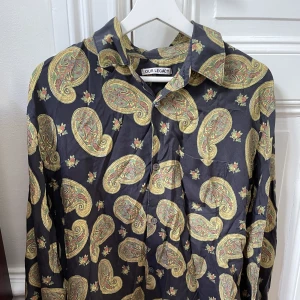 Our Legacy skjorta - Mönstrad Our Legacy-skjorta i paisley-aktigt mönster. 100% lyocell så den är supermjuk och hänger löst med 70tals-vibe (loose fit). Passar bra till allt från ljusa jeans till mörka vida kostymbyxor. Toppskick.