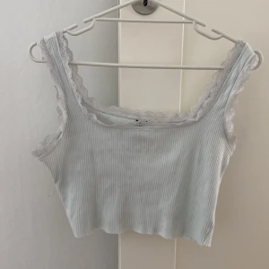 Vit ribbad topp - Vit ribbad topp med spets. Köpt på Shein. Storlek L. Använd ett fåtal gånger, alltså är den i bra skick. Dock fått lite gråare färg pga av tvätt.