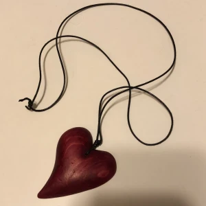 Rött trä hjärta på läder band - Hjärtat ca 1dm