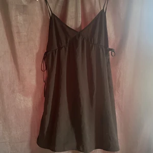 Svart klänning - Säljer denna fina klänningen som man knyter på sidorna som inte har kommit till någon användning💞