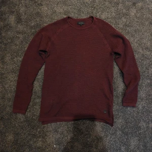 Stickad GABBA tröja - Vinröd stickad tröja från GABBA.  Ny pris 900kr En sömm på högra sidan av kragen är sliten men det går nog att fixa väldigt enkelt. Inget motiv.