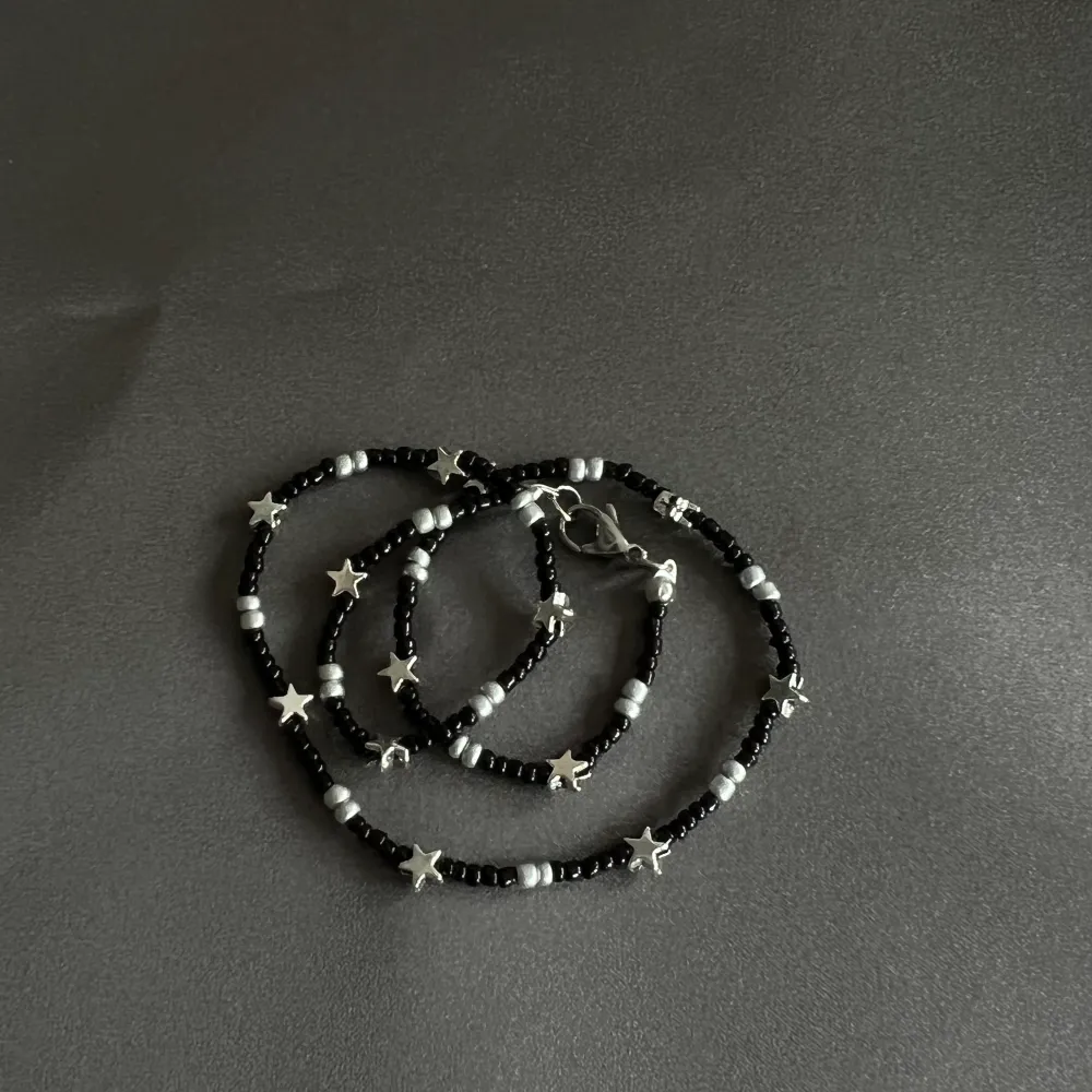 Super fint halsband gjort av svarta och silvriga pärlor blandat med små stjärnor. Halsbandet är mellan 35-40cm. Det ingår spänne och ringödlor så man kan justera halsbandet. Obs frakten kostar 15kr. Accessoarer.