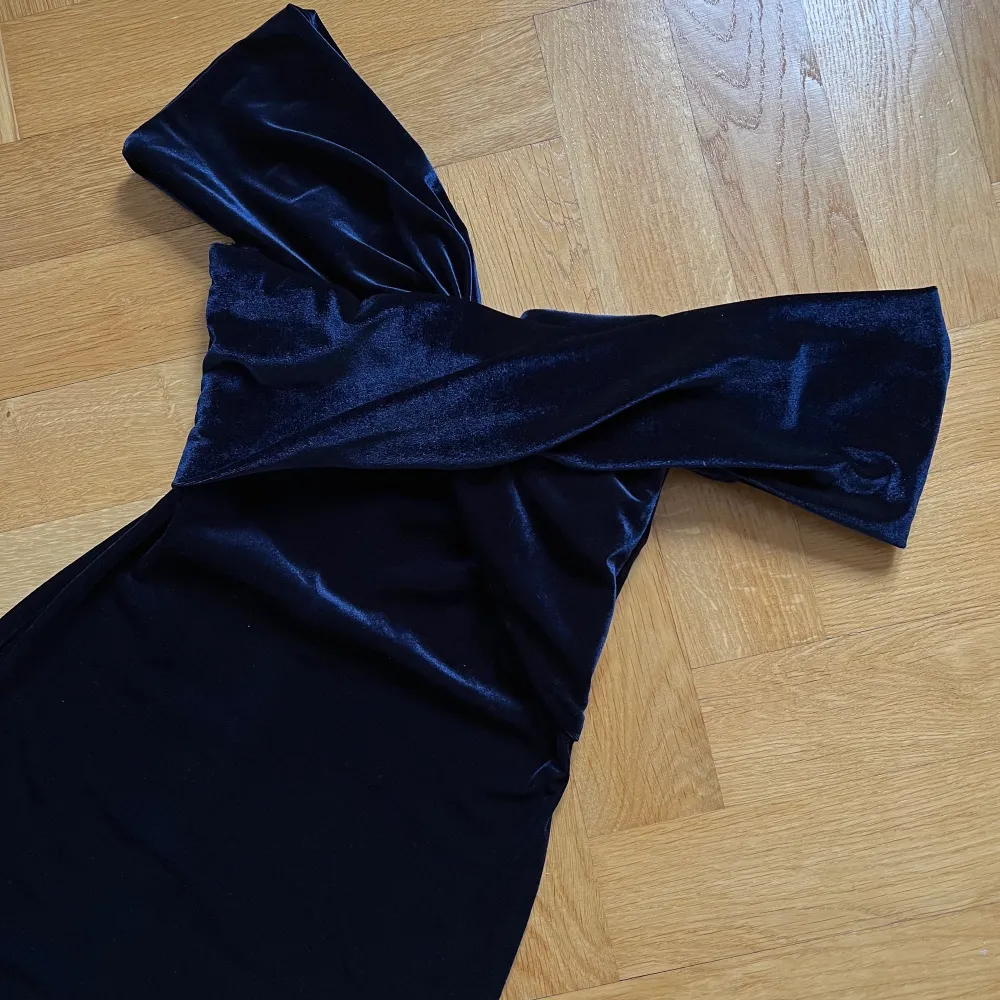 Väldigt snygg åtsittande klänning i lyxigt sammets material. Vackert dekolletaget och ärmkanter man själv kan placera hur man vill. Fin mörkblå färg och man känner sig het i den.. Klänningar.