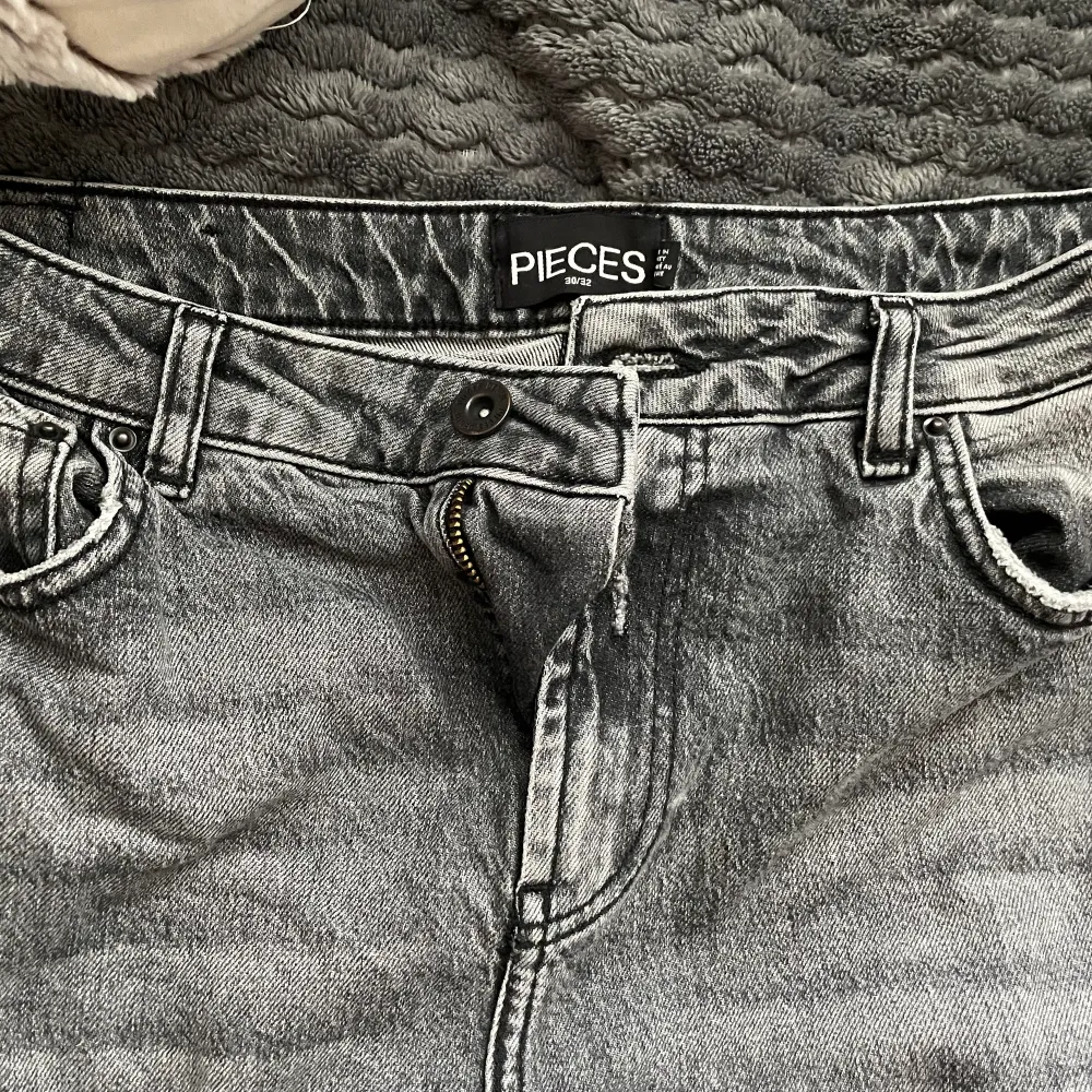 Ett par fina mörkgråa jeans (straight mom jeans) med slits på ena sidan. Knappt använda och är i bra skick. Jeans & Byxor.