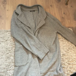 Tunn kappa från Zara - En superfin, tunnare kappa från Zara. Den är några är gammal så den finns ej kvar i lager. Varan är i fint skick och passar perfekt över en tjockare tröja nu till hösten! Ordinarie pris 399kr