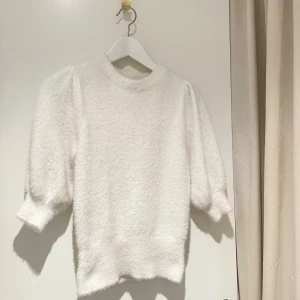 Stickad topp - Jättefin vit stickad t-shirt med puffärm från HM. Jättemjukt och lurvigt material.  Strl XS. Använd men i bra skick