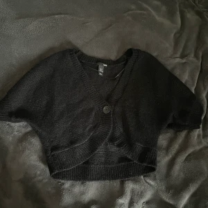 Stickad väst  - Svart stickad väst/kofta med en knapp. Väldigt fin men har bara använt en gång. 