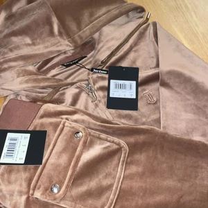 Brun juicy couture dress - Brun juicy couture dress, populär och slutsåld överallt denna färg är verkligen sjukt snygg men gillar ej hur mjukt materialet är och den sitter även stort på mig koftan är i storlek S och byxorna i XS köptes för 2200kr och är aldrig använd bara provad och den har prislapparna kvar budet börjar på 1800kr pris kan dock diskuteras vid snabb affär för fler bilder och info kontakta mig privat. KAN BYTA TILL ETT NYTT SÄTT (oanvänd) FÄRGEN LIGHTGRAYMARL- XS i båda delarna