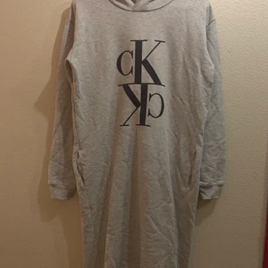 Äkta Calvin Klein mjukis klänning 176 up - Ljusgrå mjukis klänning från Calvin Klein i st 16. Ca (170-176) passar vuxen xs , s . Tryck fram och ett fastsydd emblem påsydd längst ner.  Insticks fickor från sidan  Nyskick använd Max 2-3gg. Lite skrynklig men kan strykas till innan den skickas. Lång mjukis klänning eller lång college tröja. Mys på hög nivå!!!! Porto bestämmer vi tillsammans  Finns på fler sidor 