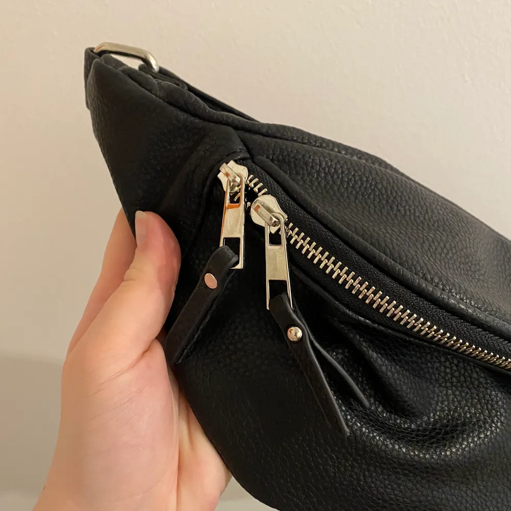 Säljer en svart magväska från Boohoo med silvriga detaljer. Aldrig använd så bra skick! . Väskor.
